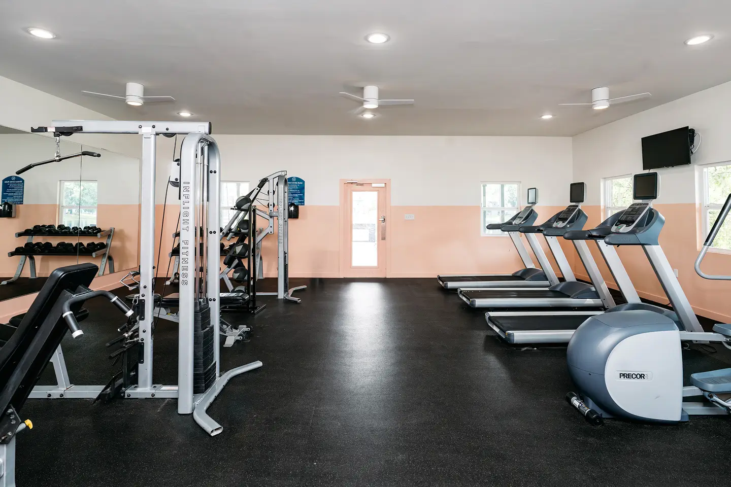Fitness center with various types of workout equipment.